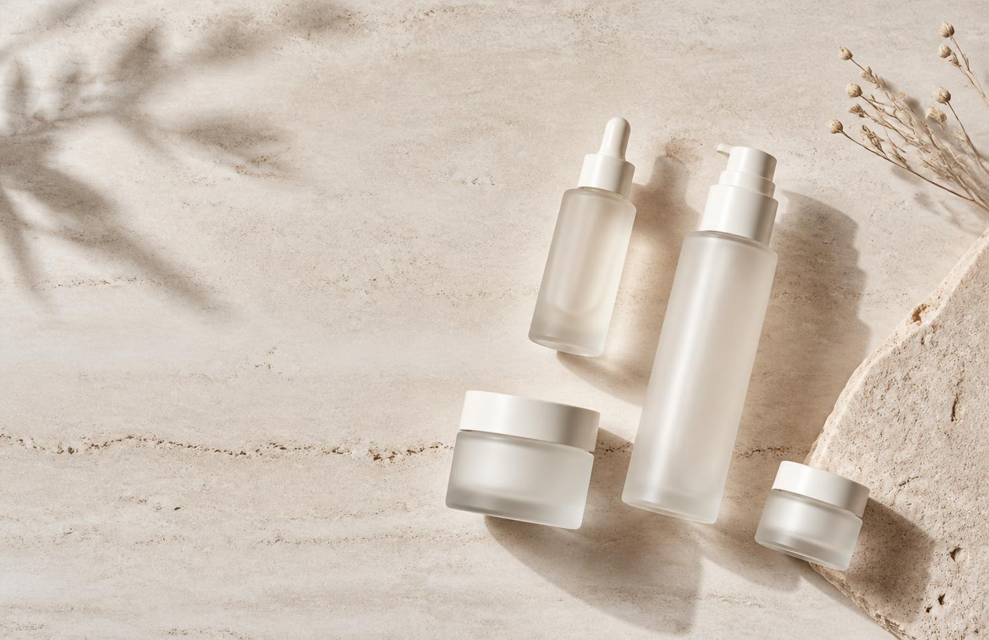 Unbranded premium skincare bottles on a pale stone surface